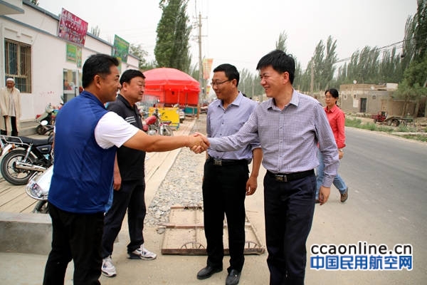 图为新疆机场集团住于田县巴什喀群村工作组组长陶润文在村委会门口欢迎观摩团带队领导