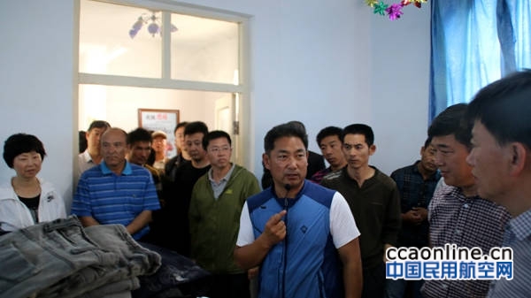 图为新疆机场集团住于田县木尕拉镇巴什喀群村工作组组长陶润文向来宾介绍“暖心超市”的相关情况